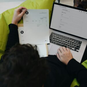 A person sitting on a bean bag chair working on a laptop